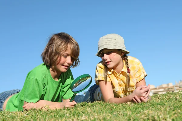Діти грають на відкритому повітрі зі збільшенням, скло — стокове фото