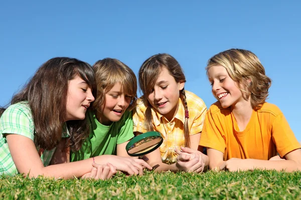 Niños en el campamento de verano jugando con lupa — Stockfoto