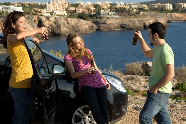 Niños menores de edad bebiendo alcohol y festejando al aire libre con el coche — Foto de Stock
