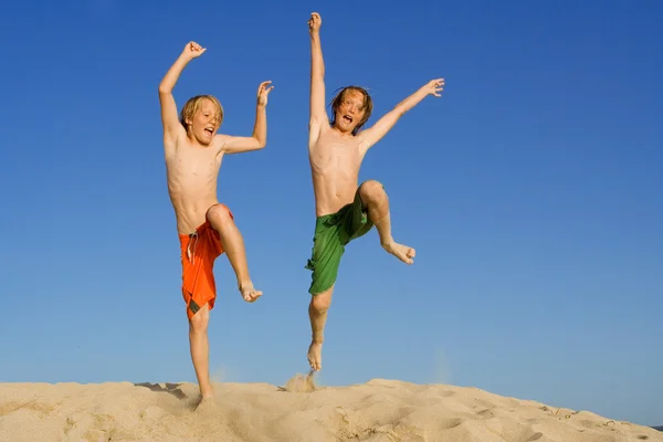 Szczęśliwe dzieci skoki na letnich wakacji na plaży — Zdjęcie stockowe
