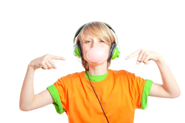 Niño soplando goma de mascar y escuchando música con auriculares — Foto de Stock