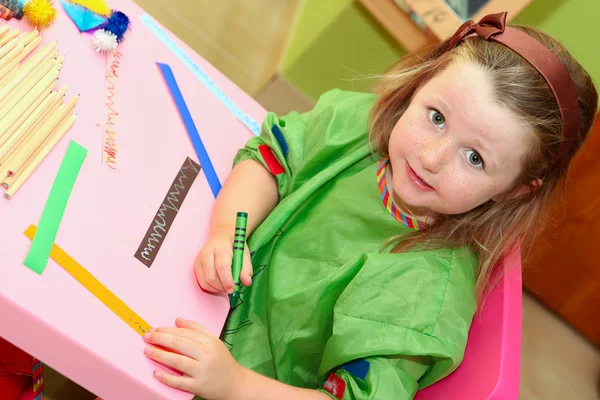 Счастливый ребенок рисует дома или в школьном саду или детском саду — стоковое фото