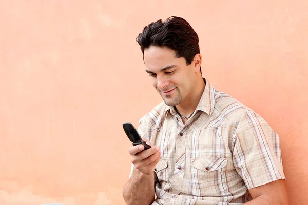 Щасливий іспаномовний чоловік з мобільним або мобільним телефоном — стокове фото