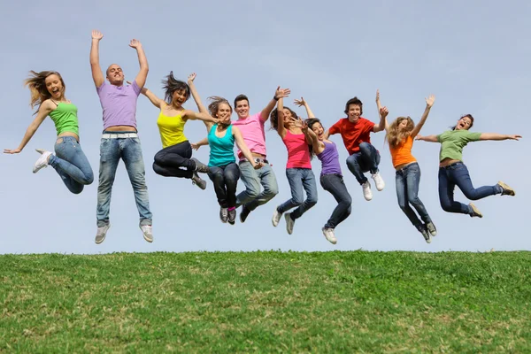 Счастливый смешанный групповой прыжок с улыбкой — стоковое фото