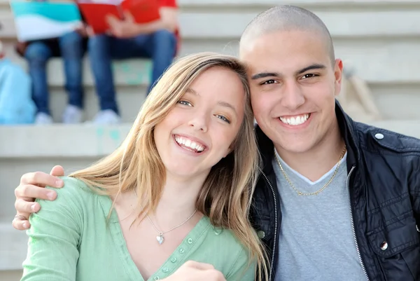 Счастливая студенческая пара в кампусе улыбается — стоковое фото