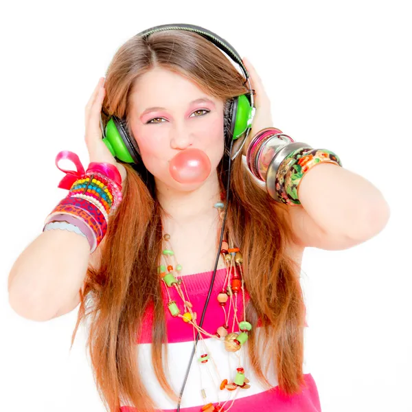 Весела дівчина слухає музику і дме бульбашку з гумкою — стокове фото