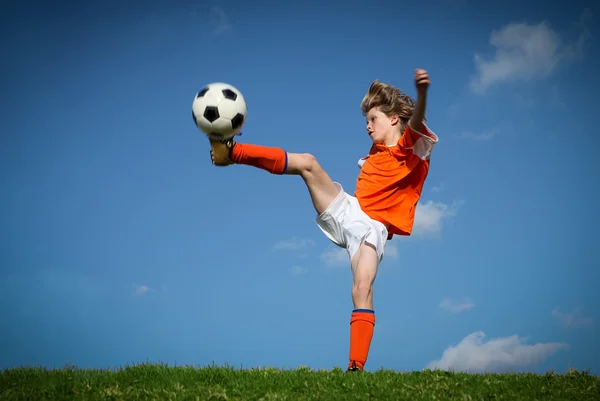 Criança chutando jogar futebol — Fotografia de Stock
