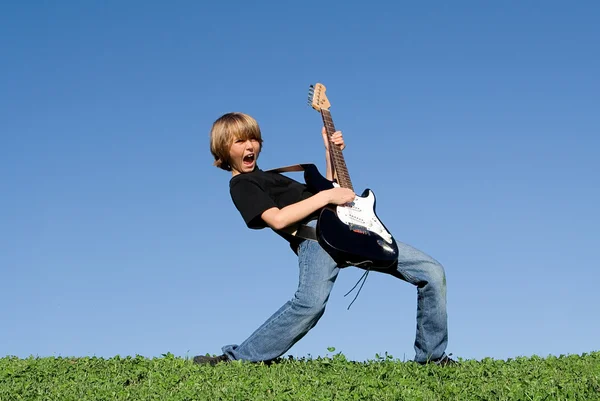 Дитина грає на гітарі та співає — стокове фото