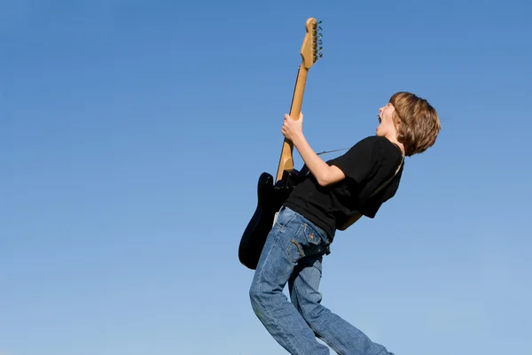 Детский музыкант играет на гитаре и поет — стоковое фото