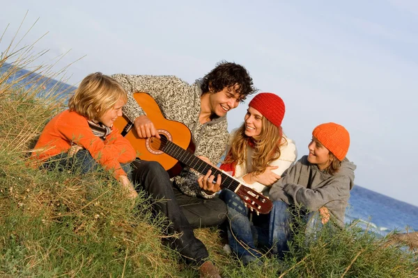 Смешанная расовая семья с гитарой в отпуске — стоковое фото