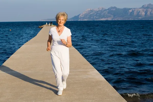 Actieve senior gepensioneerde m/v joggen op lonelyplanet — Stockfoto