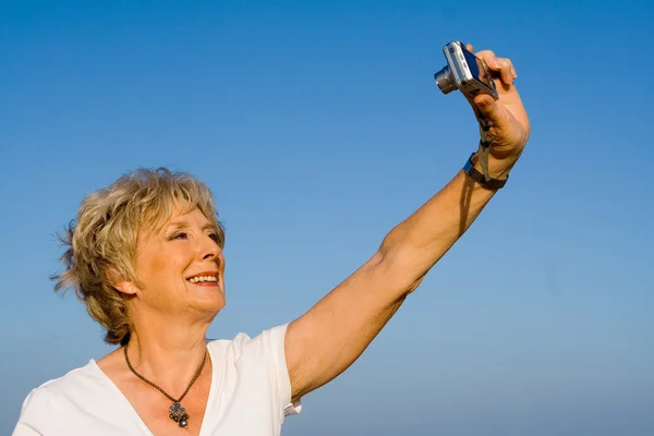 Mujer mayor tomando autorretrato con cámara en vacaciones — Foto de Stock