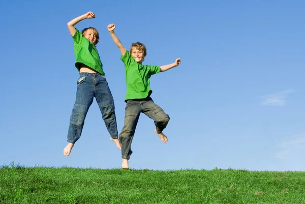 Niños felices saltando —  Fotos de Stock