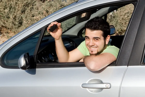 Mladý muž s klíčem k nové nebo pronájmem automobilu — Stock fotografie