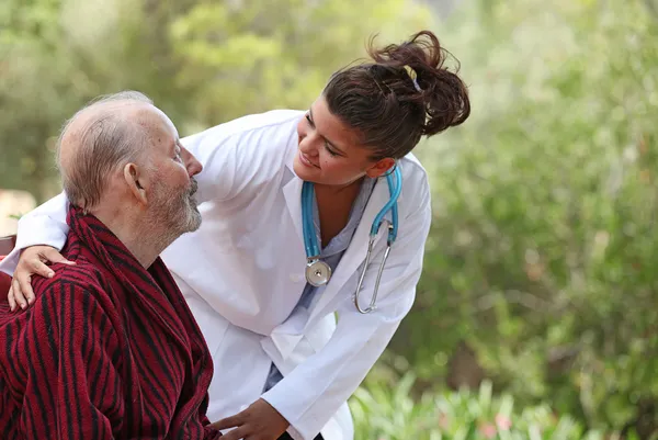 Nurse and patient home care (focus on man) Stock Picture