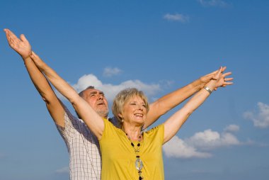 Healthy active christian senior couple arms raised in praise clipart