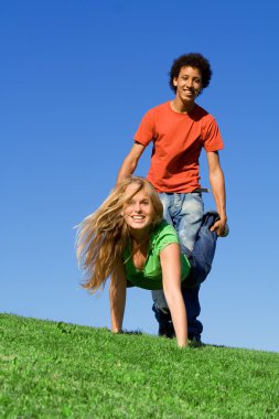 Teens, playing wheelbarrow race at summer camp clipart