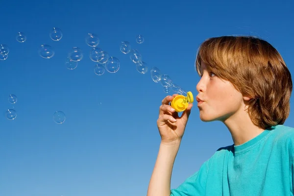 Ragazzo felice che soffia bolle con la bacchetta della bolla — Foto Stock