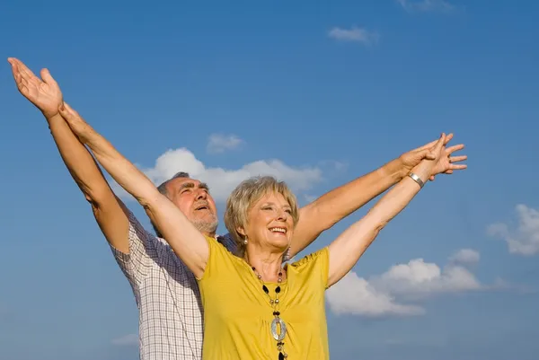 Здоровые активные христианские руки пожилой пары подняты в похвалу — стоковое фото