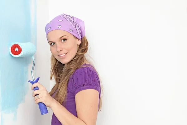 Donna pittura casa vivaio parete con rullo di vernice — Foto Stock
