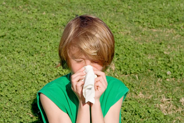 stock image Child with hay fever allergy sneezing and blowing nose outdoors