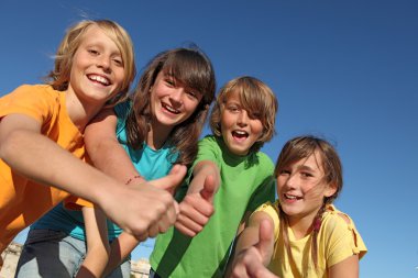 Smiling group of kids or children with thumbs up clipart