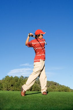 Young, man swinging golf club clipart