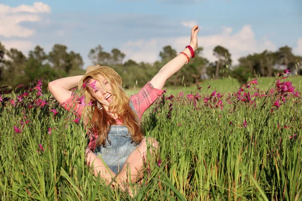 Счастливая улыбчивая летняя девочка в куче цветов — стоковое фото