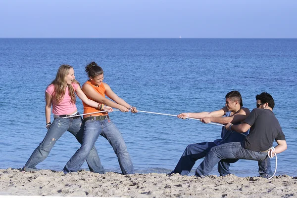 Перетягивание каната, подростки играют на пляже на летних каникулах или весенних каникулах — стоковое фото