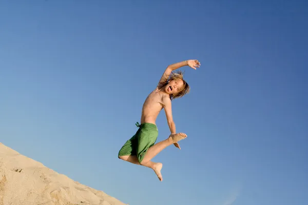 Niño feliz saltando en la playa en vacaciones de verano o vacaciones —  Fotos de Stock