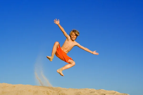 Niño saltando y jugando en la playa vacaciones de verano o vacaciones —  Fotos de Stock