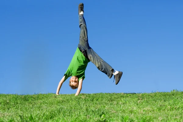 Criança feliz fazendo cartwheel no verão — Fotografia de Stock