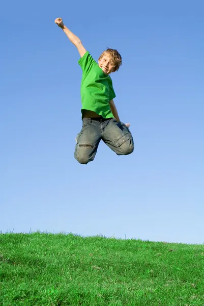 Счастливый ребенок, прыгающий на улице летом — стоковое фото