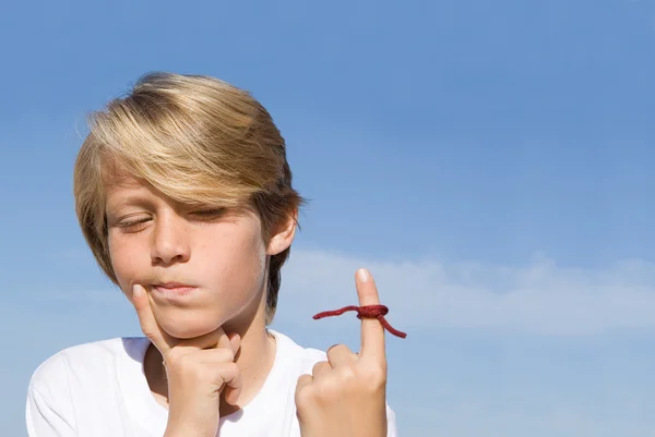 Glömsk unge med string band på fingret som en påminnelse. — Stockfoto