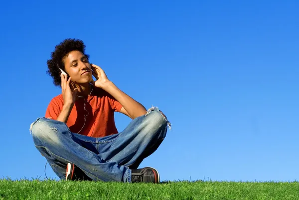 Juventud afrodescendiente escuchando música en mp4 estéreo personal o mp3 —  Fotos de Stock