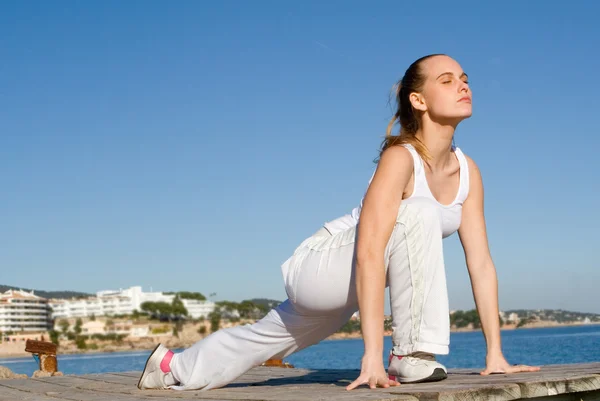 Mujer haciendo ejercicio estirándose al aire libre de vacaciones en mallorca —  Fotos de Stock