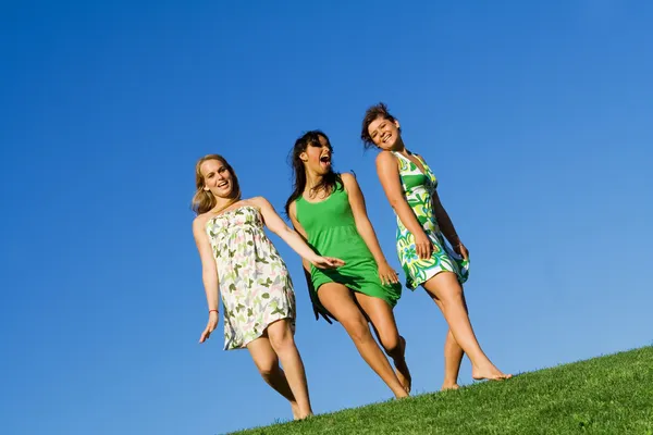 Mädchengruppe, die im Sommer auf Gras spaziert — Stockfoto