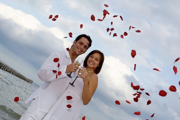 Свадьба на открытом воздухе на пляже с лепестками роз конфетти — стоковое фото