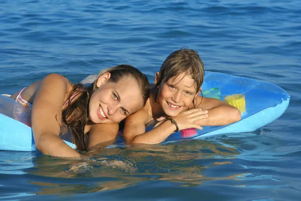 Jovem família feliz, mãe e criança brincando no mar — Fotografia de Stock