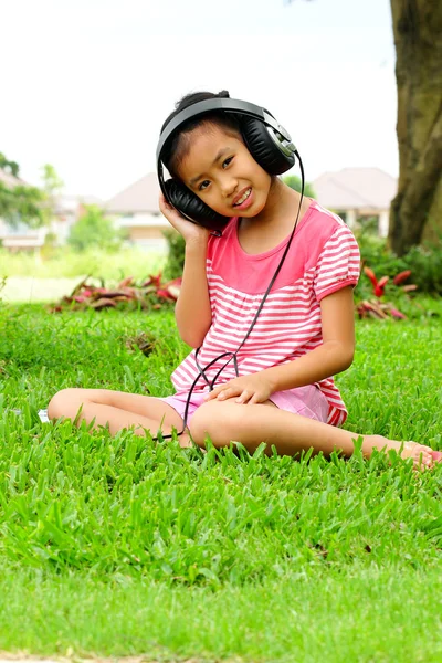 Una joven asiática escuela chica escuchar música en línea — Foto de Stock