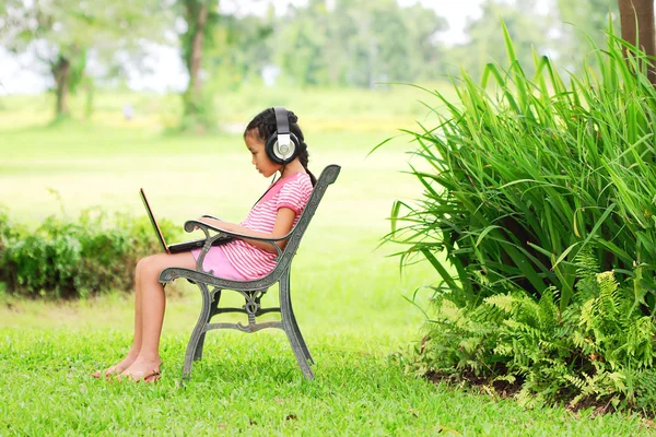 Jong meisje zitten en luisteren naar muziek — Stockfoto