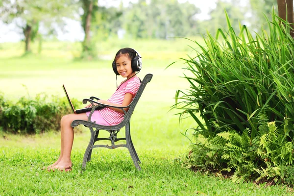 年轻的女孩坐在和听音乐 — 图库照片