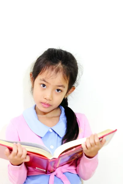 Mladá dívka sedí a čtení knihy — Stock fotografie