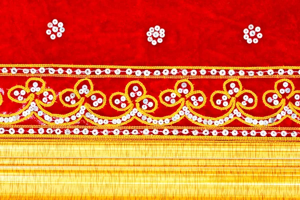 Красная ткань, вышитые и золотые деревянные рамки — стоковое фото