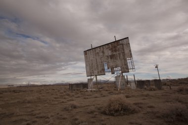 Old abandoned drive-in movie theater on a cloudy day desert clipart