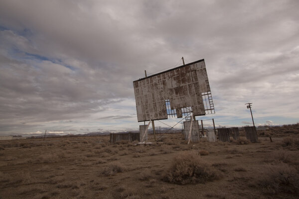 Old abandoned drive-in movie theater on a cloudy day desert