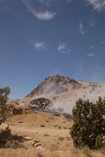 Smoking desert hillside from a fire — Stock Photo, Image