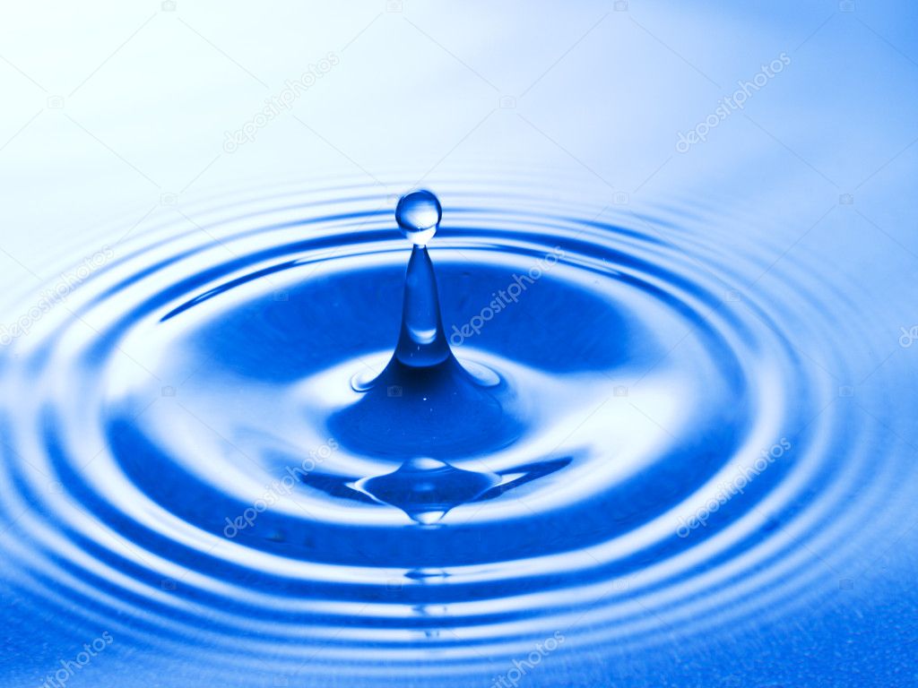 Falling water drop close up in blue.