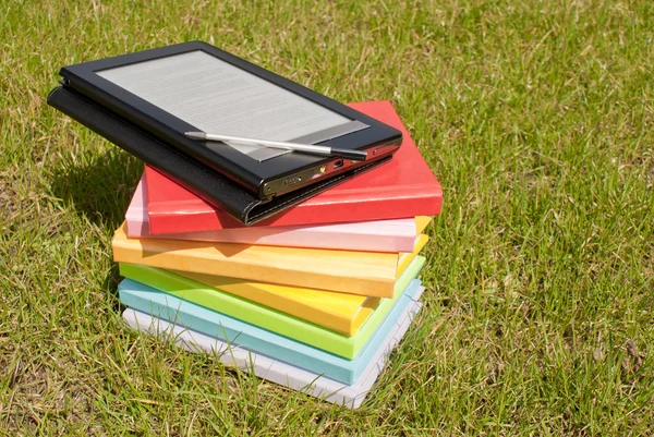 Lector de libros electrónicos con una pila de libros — Foto de Stock