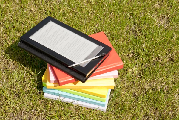 Lector de libros electrónicos con una pila de libros —  Fotos de Stock